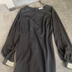 A nice black dress with sleeves that are open (showing arms)